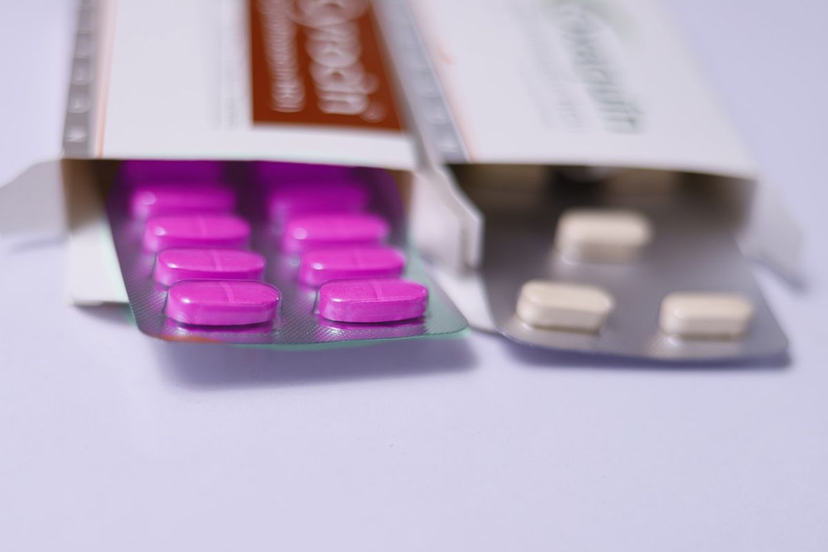 Paracetamol-tabletter og glass vann for smerte- og feberlindring