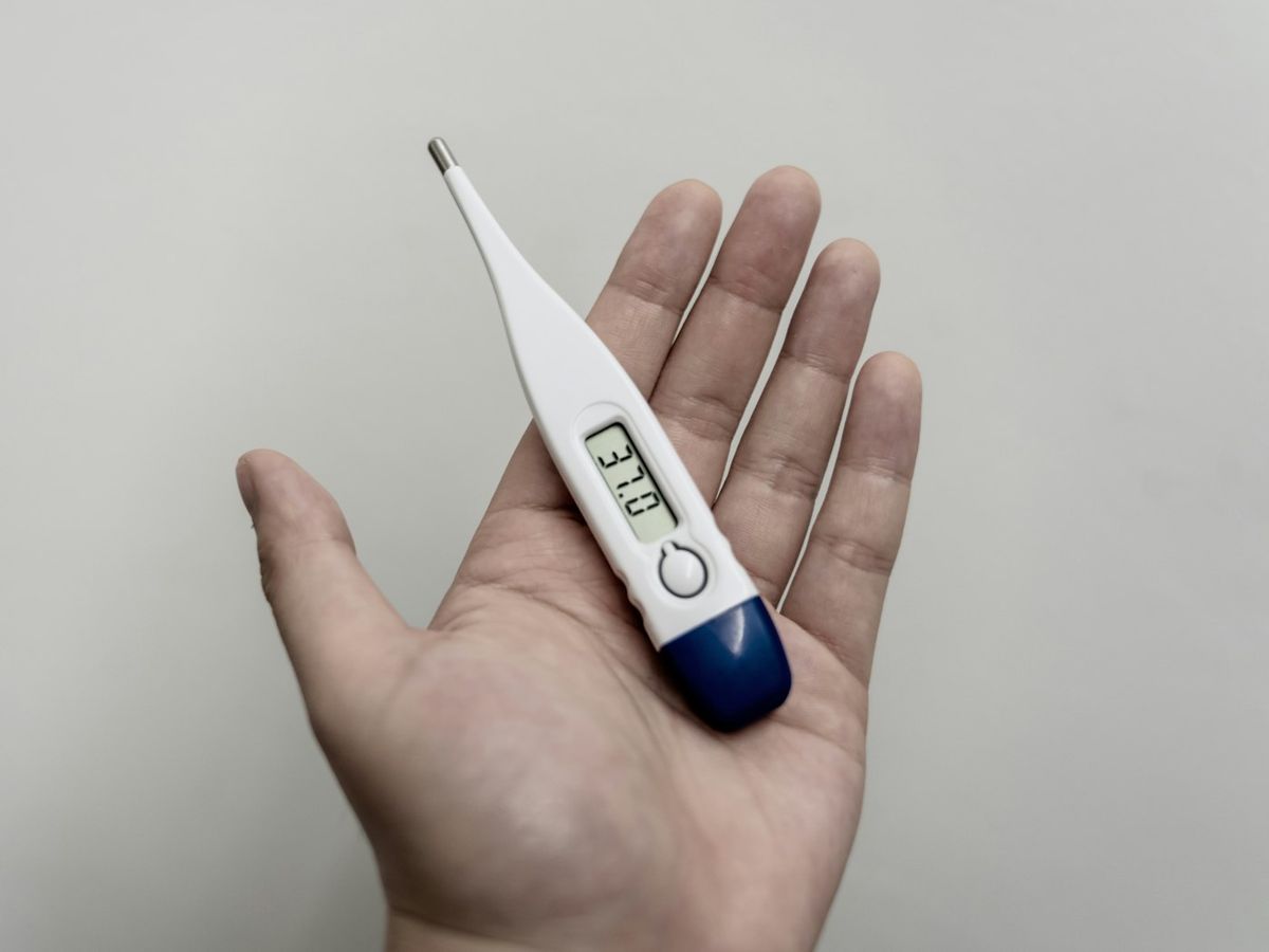 Termometer i hand som viser feber